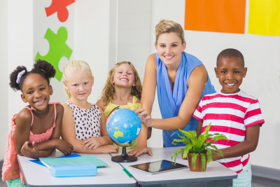 teacher discussing globe with kids in classroom